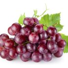 Ripe red grape with leaves isolated on white
